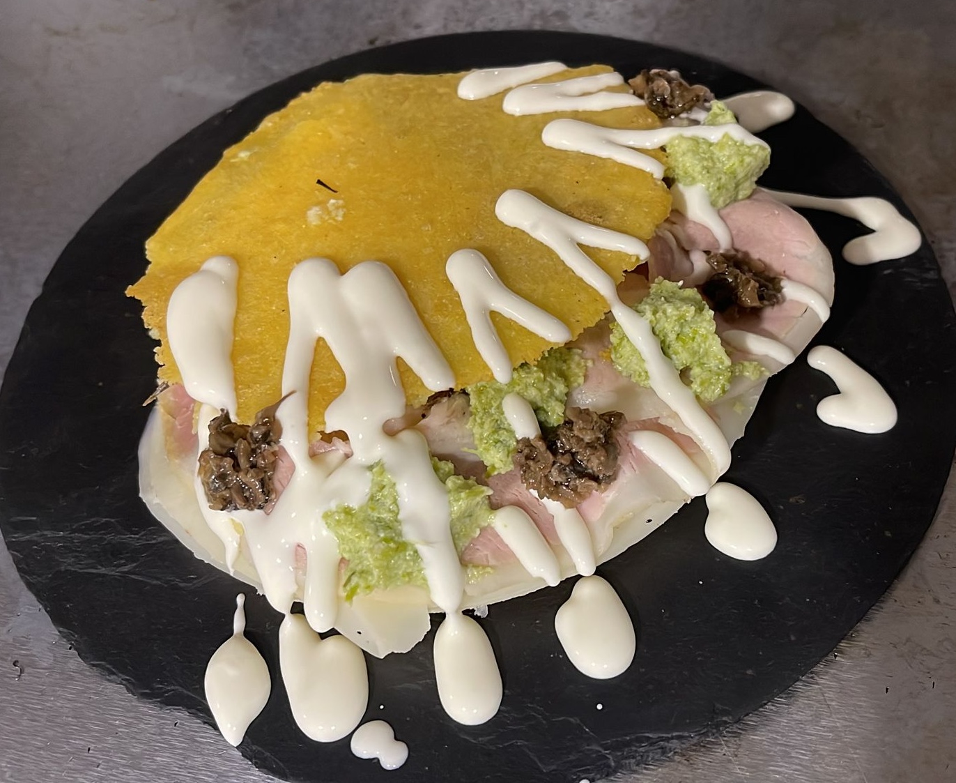 Arepa de porchetta, rúcula, trufa y crema de ricotta